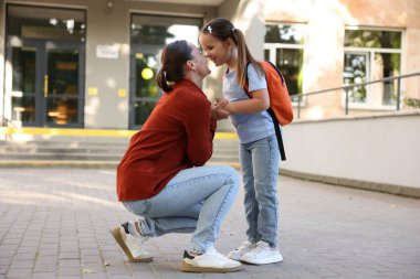 Anne kızını açık hava okuluna götürüyor.
