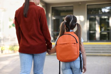 Anne kızını açık hava okuluna götürüyor.