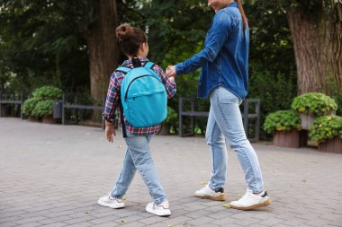 Anne kızını açık hava okuluna götürüyor.