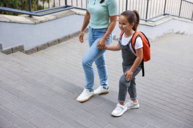 Anne kızını açık hava okuluna götürüyor, yakın çekim.
