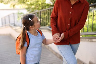 Anne kızını açık hava okuluna götürüyor, yakın çekim.