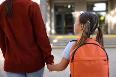 Anne kızını açık hava okuluna götürüyor.