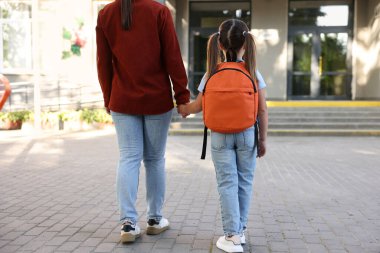 Anne kızını açık hava okuluna götürüyor.