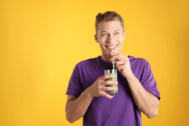 Turuncu arka planda samandan meyve suyu içen adam, metin için boşluk