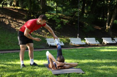 Dışarıda profesyonel antrenörle egzersiz yapan genç bir kadın. Metin için boşluk