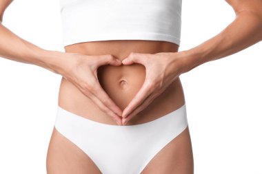 Düz göbekli kadın, beyaz arka planda kalp hareketi yapıyor, yakın plan.