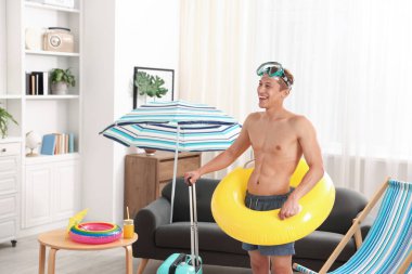 Dalış maskesi, bavulu ve şişme yüzüğü olan mutlu bir adam. Denizde tatilin hayalini kuruyorum.