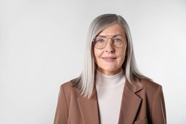 Портрет красивой пожилой женщины на светлом фоне. Пространство для текста