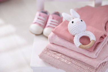 Temiz bebek kıyafetleri, ayakkabılar ve aksesuarlar kapalı bir sandalyede, yakın plan. Metin için boşluk