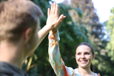 Profesyonel kişisel antrenörü olan genç adam dışarıda beşlik çakıyor.