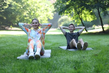 Genç adam profesyonel antrenörle dışarıda egzersiz yapıyor.