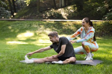 Genç adam dışarıda profesyonel antrenörle egzersiz yapıyor. Metin için boşluk