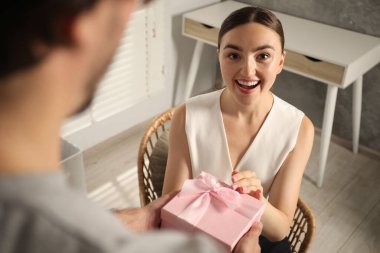 Hayaller gerçek olur. Erkek sürpriz kadın hediyesiyle evde, yakın plan.