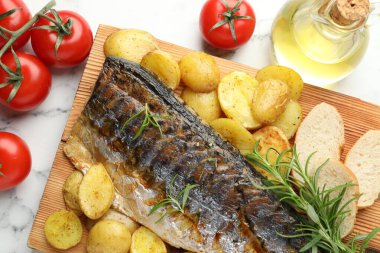 Lezzetli kavrulmuş uskumru, baharatlar ve sebzeler beyaz mermer masada, düz yerde. Ev yapımı deniz ürünleri yemeği.