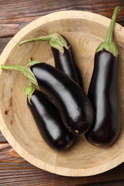 Tahta masadaki kasede taze patlıcanlar.