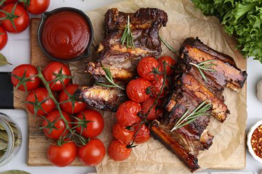 Biberiyeli biftek kaburgaları, domatesler ve diğer ürünler masada.