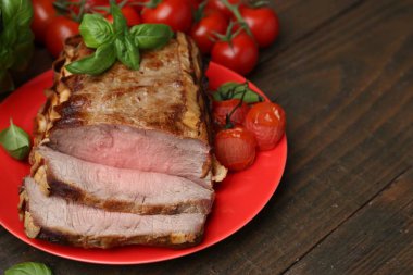 Lezzetli pişmiş et, domates ve fesleğen, ahşap masada, yakın plan. Metin için boşluk