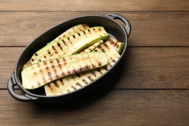 Ahşap masadaki fırın tabağında nefis ızgara kabak dilimleri.