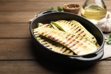 Ahşap masadaki fırında pişmiş kabak dilimleri, yakın plan.