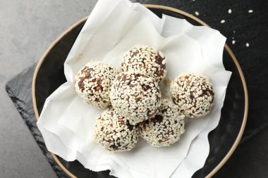 Gri masadaki kasede fındık ve susam tohumlu lezzetli çikolata şekerlemeleri.