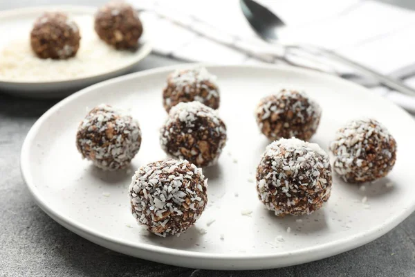 Gri masada fındıklı ve hindistan cevizli lezzetli çikolatalar, yakın plan.