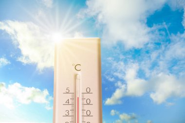 Güneşli bir günde mavi gökyüzüne karşı termometrede son derece yüksek sıcaklık. Yaz havası