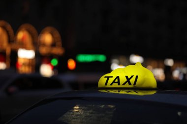 Şehir caddesinde sarı kareli işaretli taksi, yakın çekim.