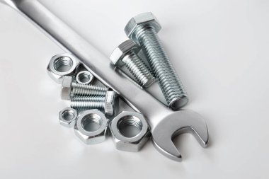 Beyaz arka planda metal anahtar, cıvata ve fındık