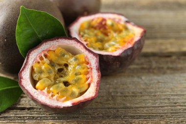 Taze tutku meyveleri ve ahşap masada yeşil yapraklar, yakın plan. Metin için boşluk