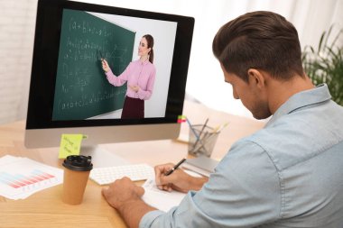 E-öğrenme konsepti. Öğrenci masadaki bilgisayar aracılığıyla öğretmenle çevrimiçi görüntülü sohbet ediyor