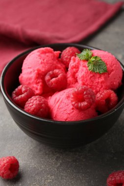 Lezzetli ahududu şerbeti, taze böğürtlenler ve gri desenli masada nane şekeri, yakın plan.