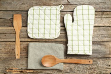 Fırın eldiveni ve diğer mutfak gereçleri ahşap masada, düz yatıyordu.