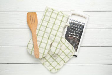 Fırın eldiveni, tutkal, jartiyer ve spatula beyaz ahşap masa, düz yatıyordu.