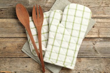 Fırın eldiveni ve diğer mutfak gereçleri ahşap masada, düz yatıyordu.