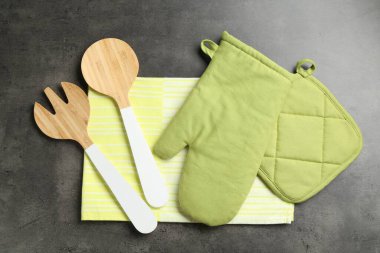 Yeşil fırın eldiveni ve diğer mutfak gereçleri koyu dokulu masa, düz yatıyordu.