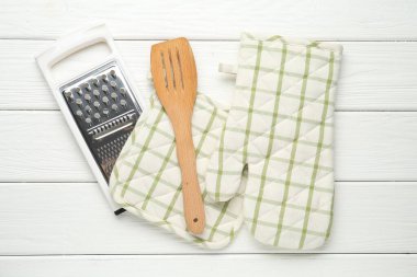 Fırın eldiveni, tutkal, jartiyer ve spatula beyaz ahşap masa, düz yatıyordu.