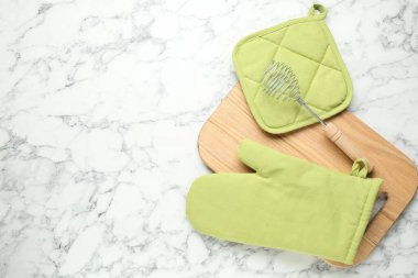 Fırın eldiveni, tutkal ve diğer mutfak aletleri beyaz mermer masada, düz yerde. Metin için boşluk