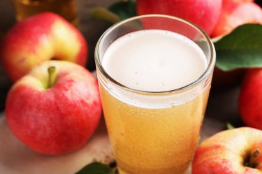 Lezzetli elma şarabı, cam ve elmalar masada, yakın plan.