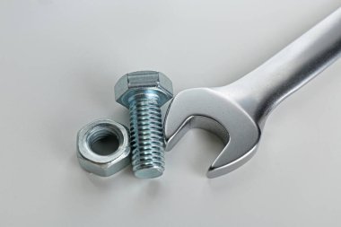 Metal anahtar, cıvata ve fındık beyaz arka planda, yakın plan