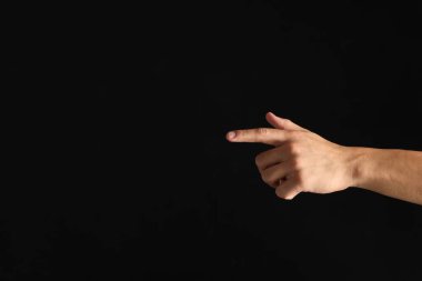 Siyah arka planda bir şeye dokunan adam, yakın plan. Metin için boşluk