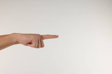 Adam açık gri arkaplanda bir şeye dokunuyor, yakın plan. Metin için boşluk