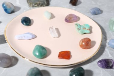 Açık gri masada birçok farklı iyileştirme taşı var. Yakın plan.