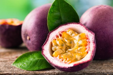 Taze tutku meyveleri ve yeşil yapraklar ahşap masada, yakın plan.