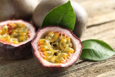 Taze tutku meyveleri ve yeşil yapraklar ahşap masada, yakın plan.