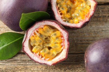 Taze tutku meyveleri ve yeşil yapraklar ahşap masada, düz yatıyordu.