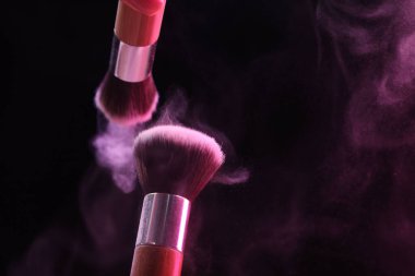 Siyah arka planda pembe göz farlı makyaj fırçaları, yakın plan. Metin için boşluk