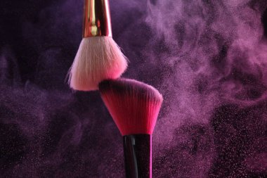 Renkli göz gölgeli makyaj fırçaları siyah arka planda neon ışıkları, yakın plan