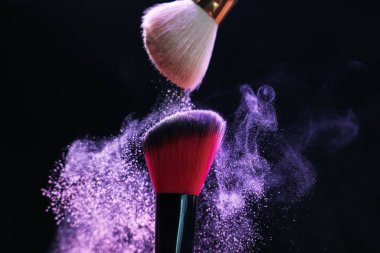 Siyah arka planda mor göz farlı makyaj fırçaları, yakın plan