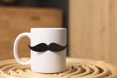 Babalar Günün kutlu olsun. Kahve masasında kağıt bıyıklı fincan, yakın plan. Metin için boşluk