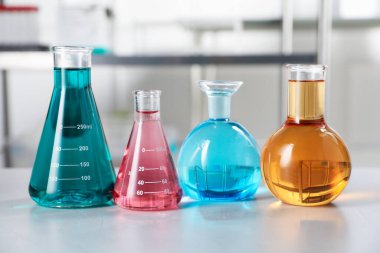 Açık masa üzerinde renkli sıvılar bulunan farklı bir laboratuar cam.